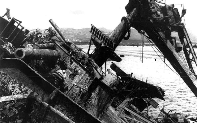 In this May 24, 1943, photo, the capsized battleship USS Oklahoma is lifted out of the water at Pearl Harbor in Honolulu.