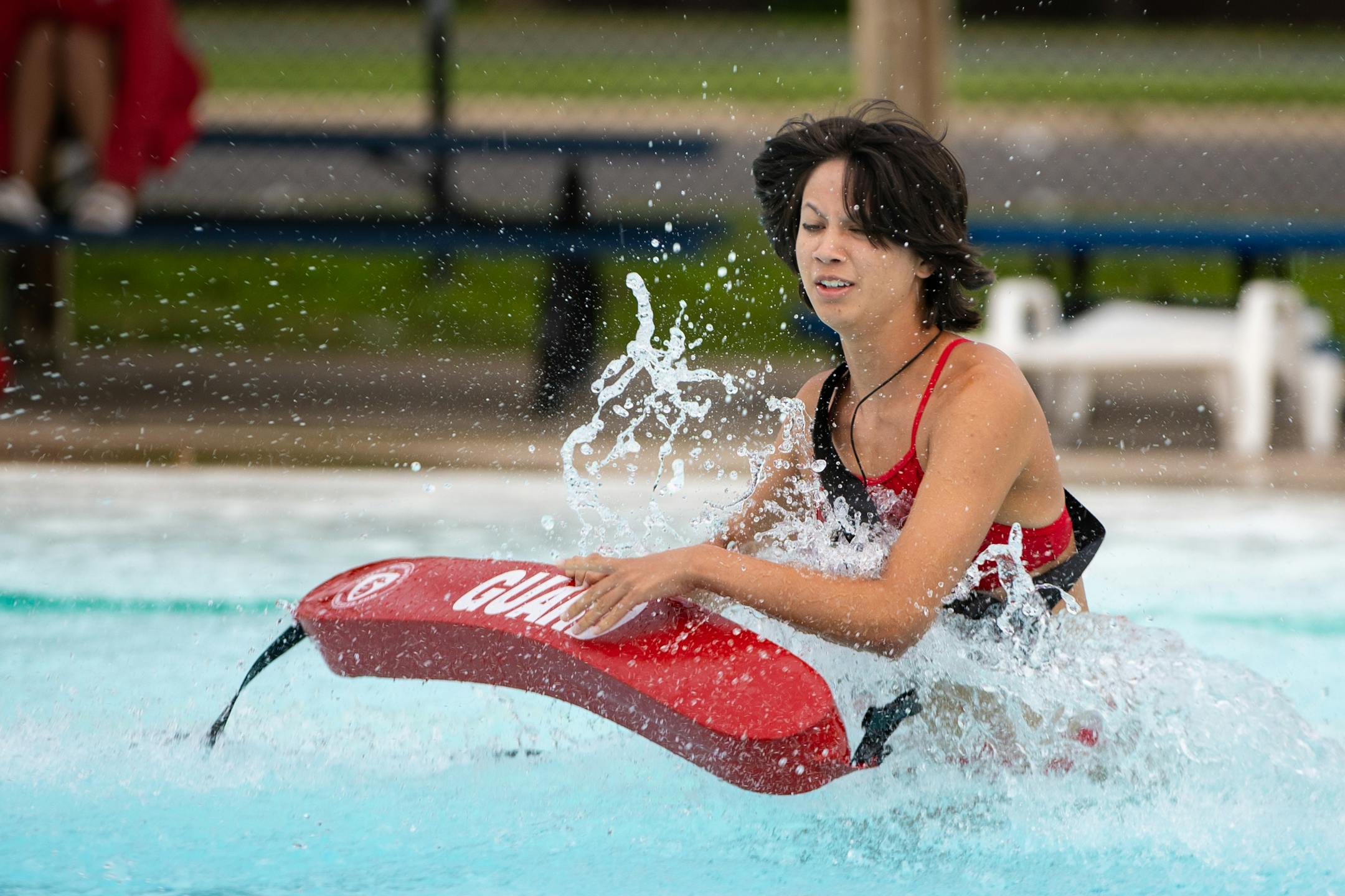 A student leaps into the water during a practice lifeguarding drill.