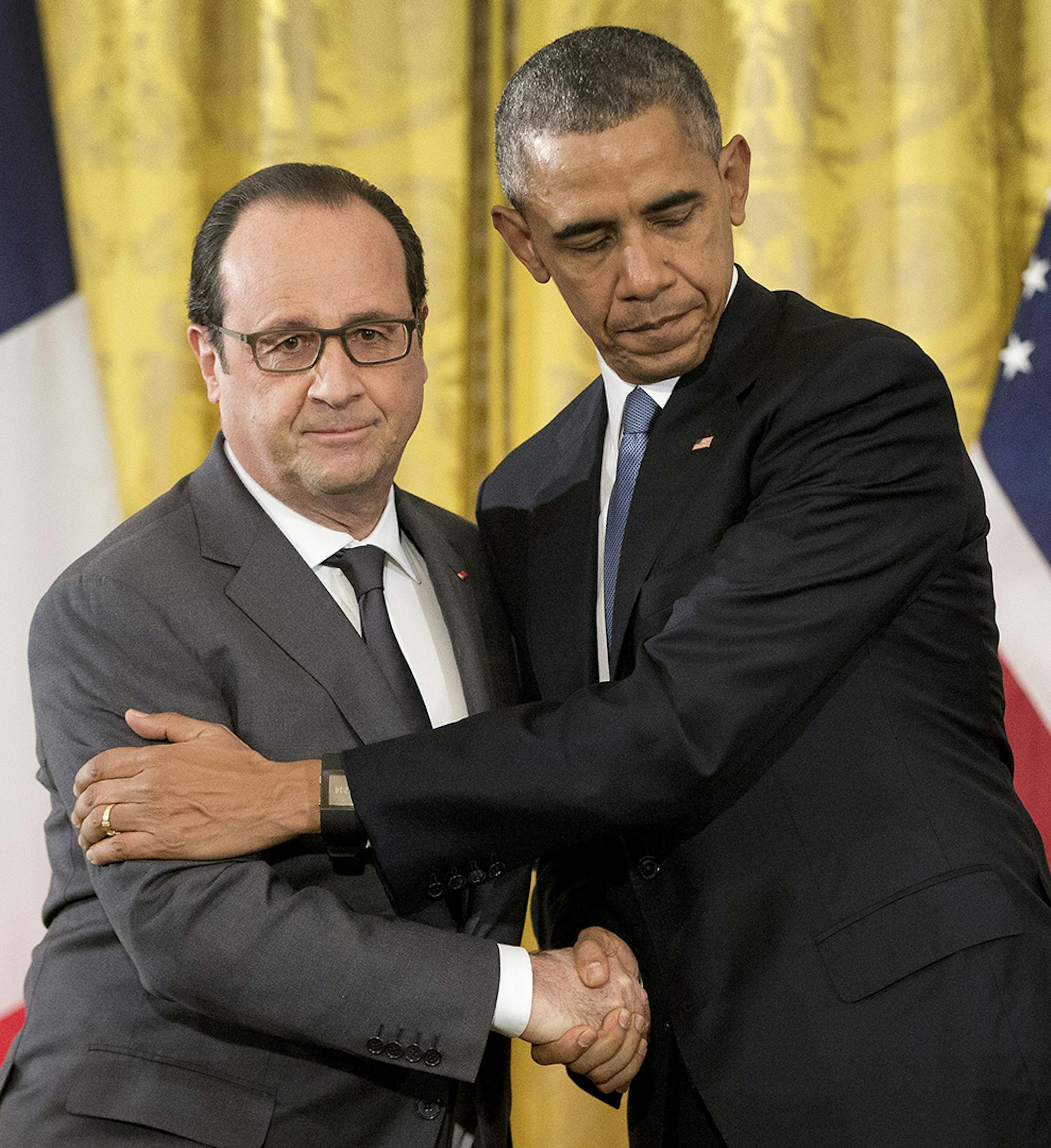 President Barack Obama shakes hands with French President Francois Hollande of France embrace during their news conference in the East Room of the White House in Washington, Tuesday, Nov. 24, 2015. Hollande's visit to Washington is part of a diplomatic offensive to get the international community to bolster the campaign against the Islamic State militants. (AP Photo/Pablo Martinez Monsivais) ORG XMIT: MIN2015112514091332
