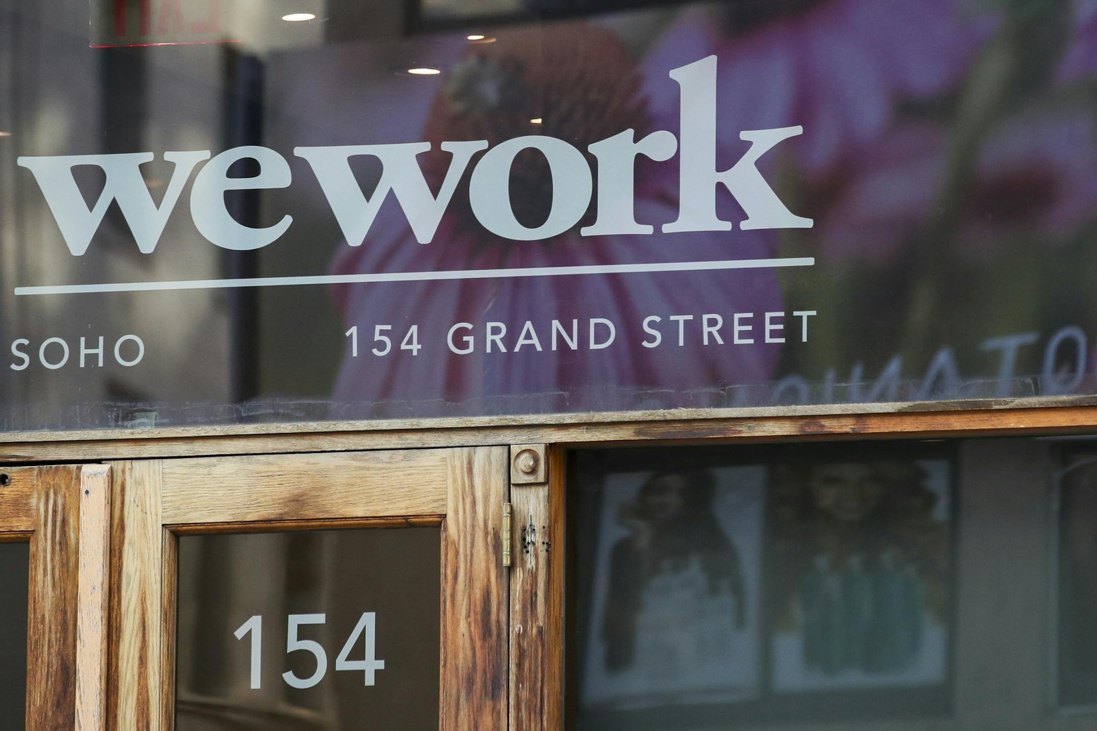 In this Tuesday, Oct. 15, 2019, photo a WeWork logo is seen at the entrance to one of their office spaces in the SoHo neighborhood of New York. (AP Photo/Mary Altaffer)
