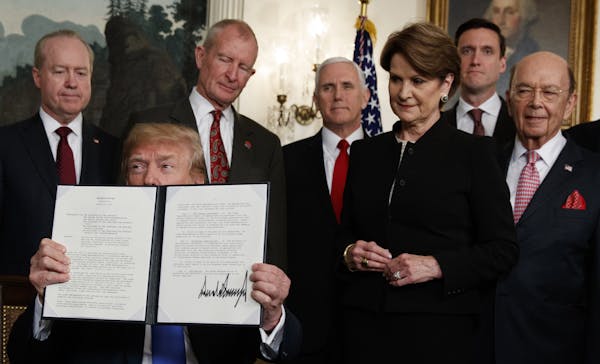 President Donald Trump displayed the signed presidential memorandum imposing tariffs and investment restrictions on China during a White House ceremon