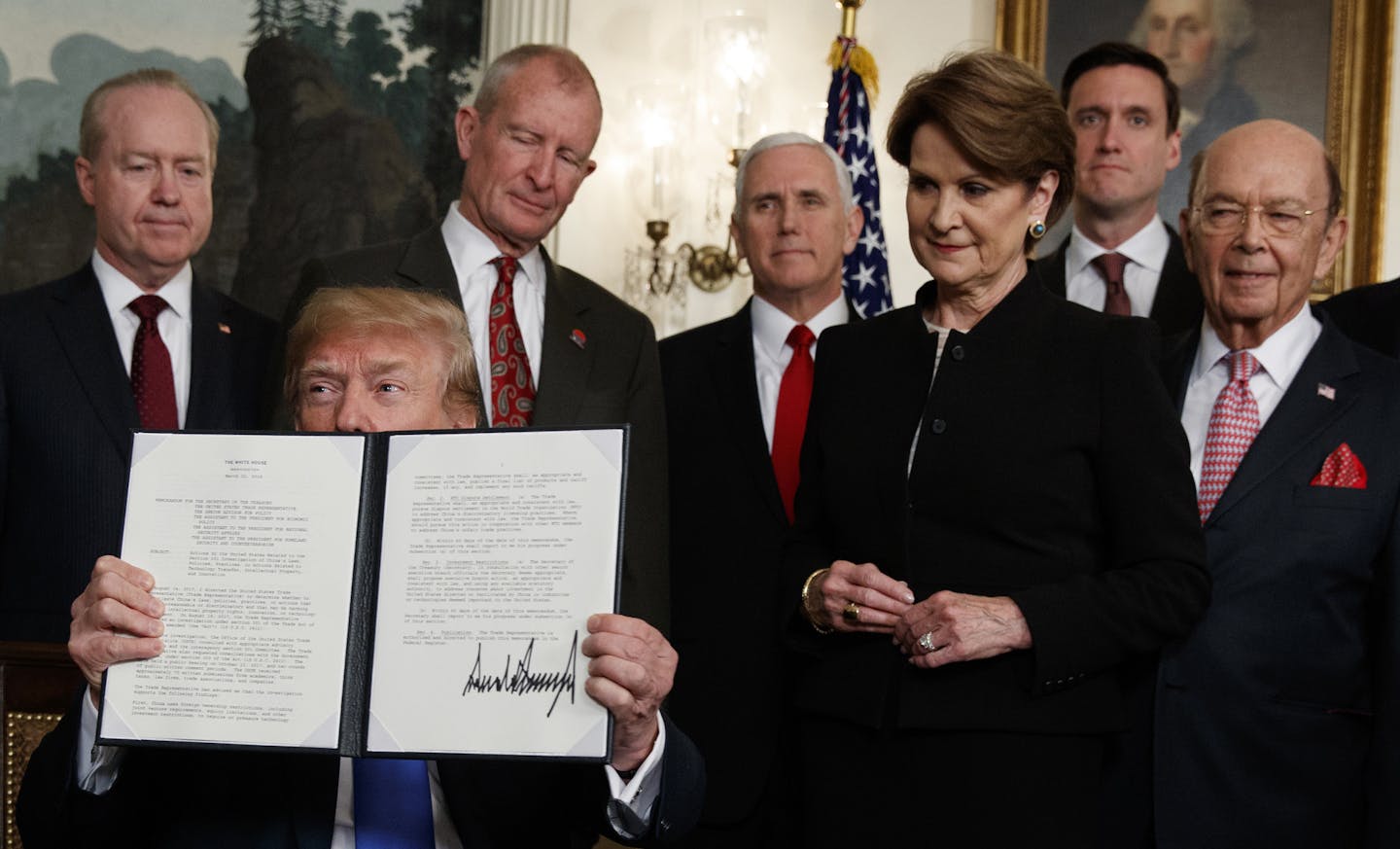 President Donald Trump displayed the signed presidential memorandum imposing tariffs and investment restrictions on China during a White House ceremony on Thursday.