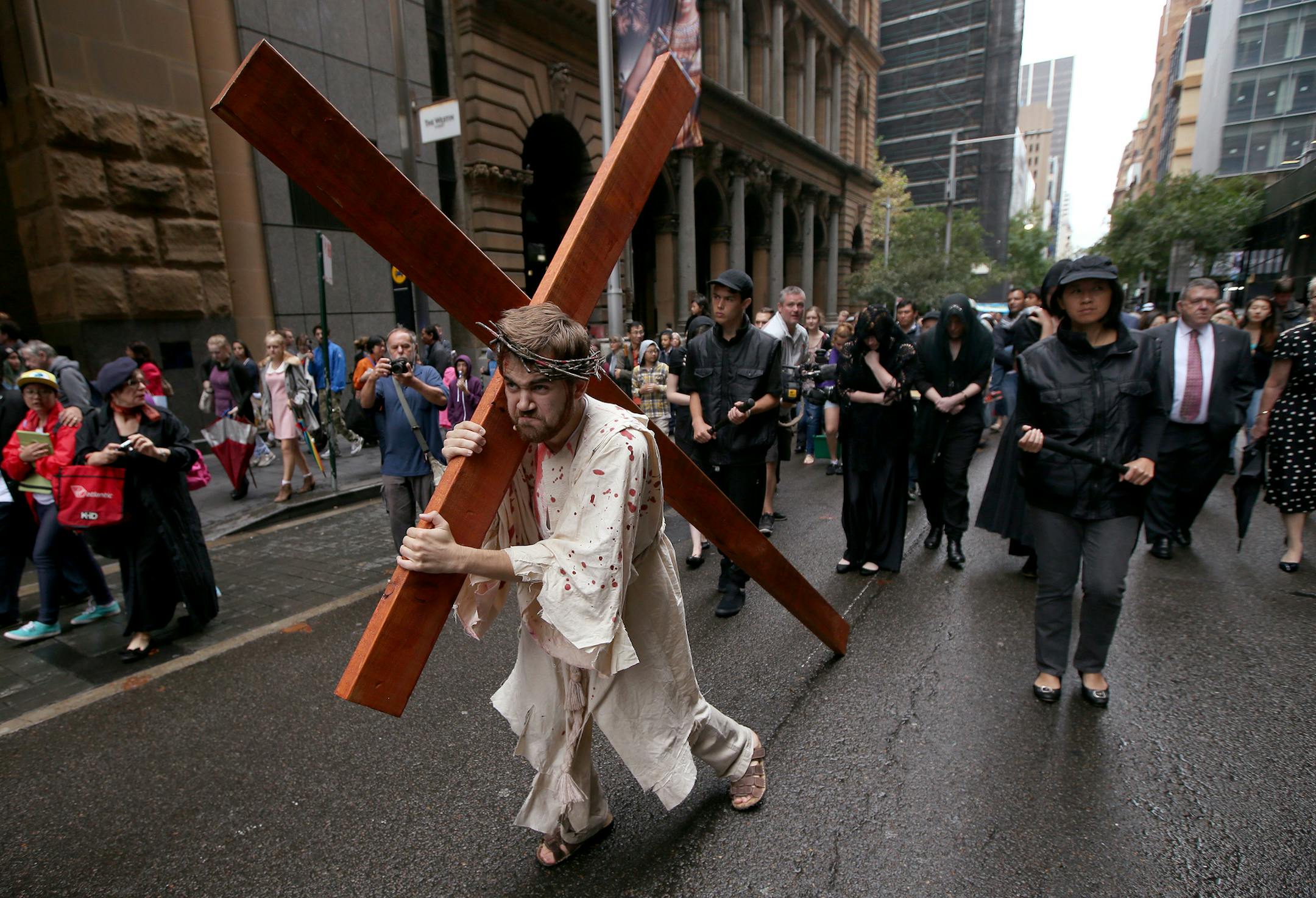 Brendan Paul plays the part of Jesus during a re-enactment of the crucifixion of Christ in Sydney, Friday, April 3, 2015. Members of the Wesley Mission use a modern interpretation of the recreation of Jesus' journey to the cross before a Good Friday service is held. (AP Photo/Rick Rycroft)