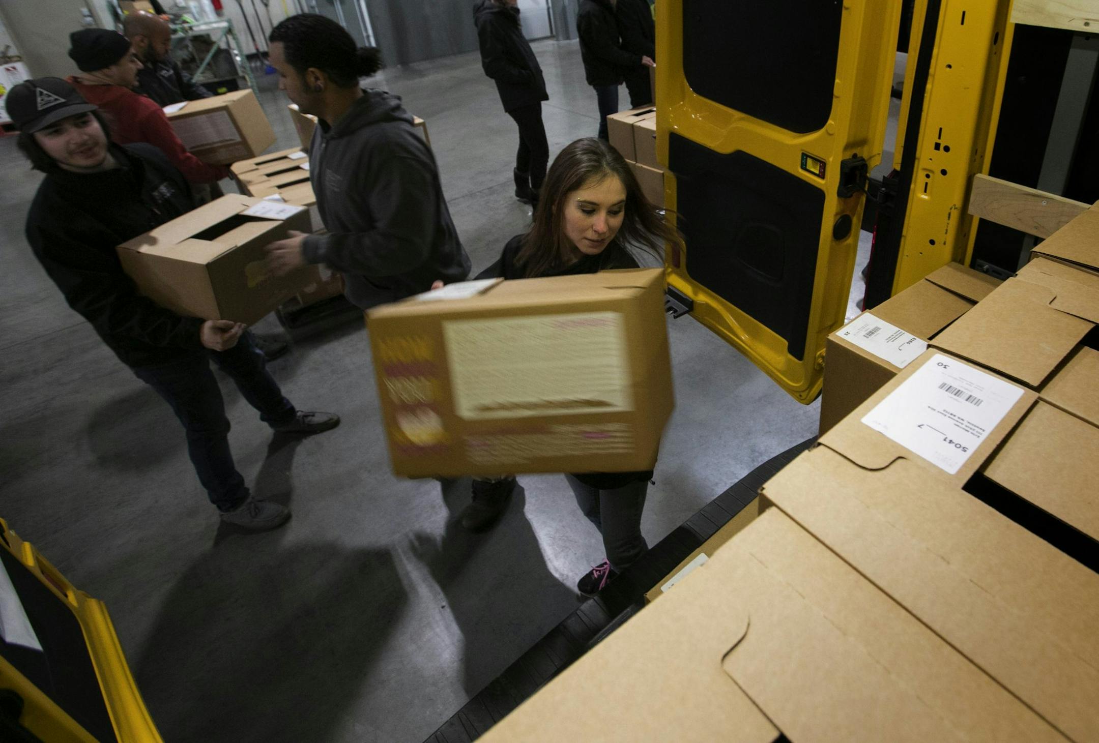 Taylor Knutson loads a box of produce into a delivery van as the drivers all help each other load their vans before taking off for their afternoon deliveries at Imperfect Produce in Des Moines, Wash., on December 14, 2017. (Ellen M. Banner/Seattle Times/TNS)
