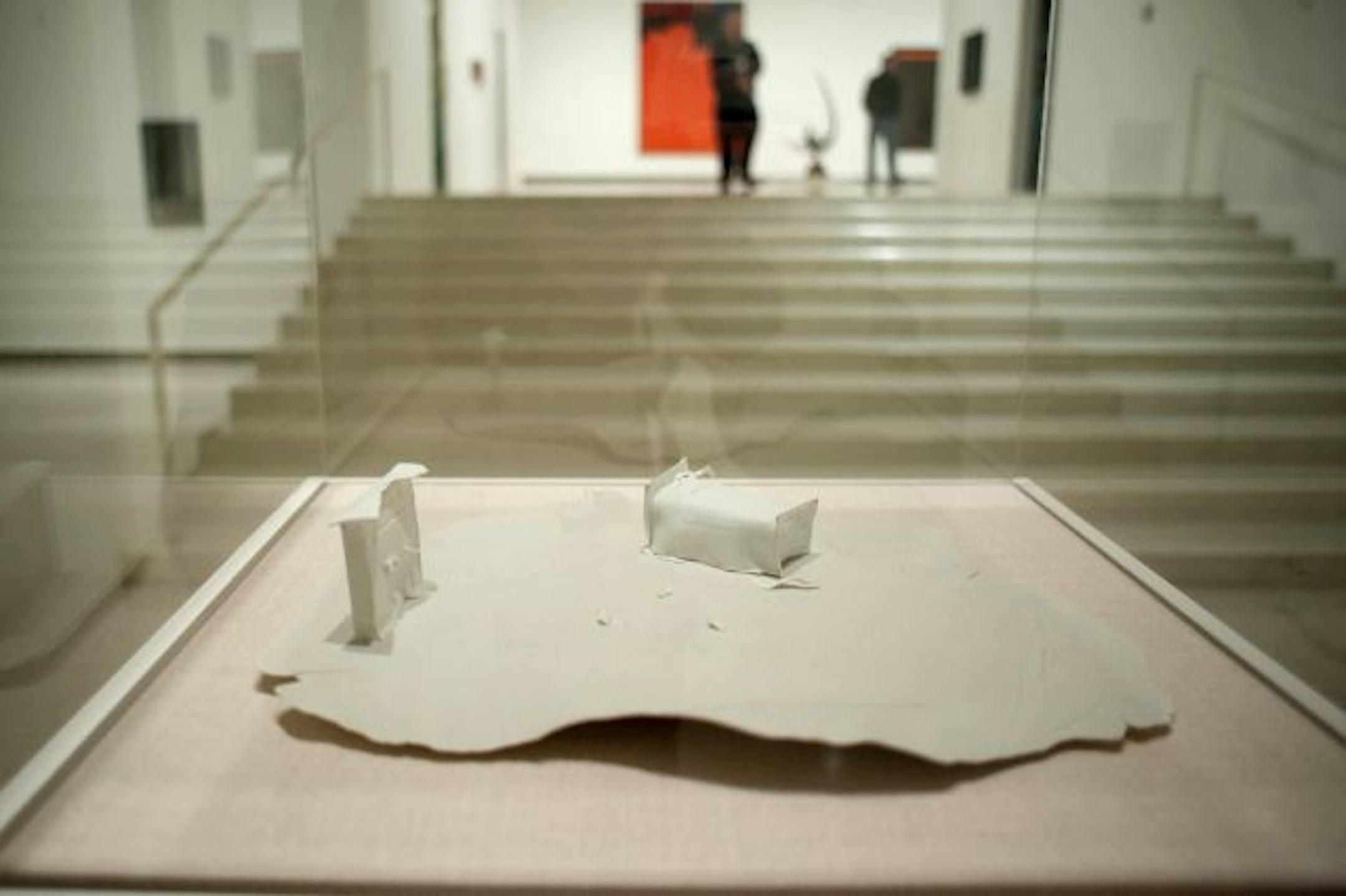 A dollhouse-sized porcelain sculpture by Minneapolis artist Tom Rose contrasts with mural-sized photos in the show's architecture-of-dreamland segment.