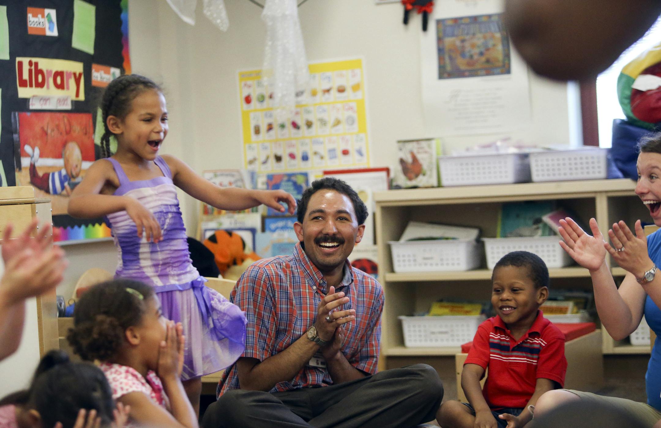 During a circle numbers game Daiyah Klatt, standing, correctly answers the question as Jordan Richardson, center, and teacher Ashley Peters, right, look on Thursday, June 4, 2014, at Earle Brown Elementary School in Brooklyn Center, MN. Richardson is a teaching aide at the school and is blind and has told the students but isn't sure they comprehend or care. "Does it matter?" he asks. "Does Being blind really have anything?"] (DAVIDJOLES/STARTRIBUNE) djoles@startribune.com Jordan Richardson, lega