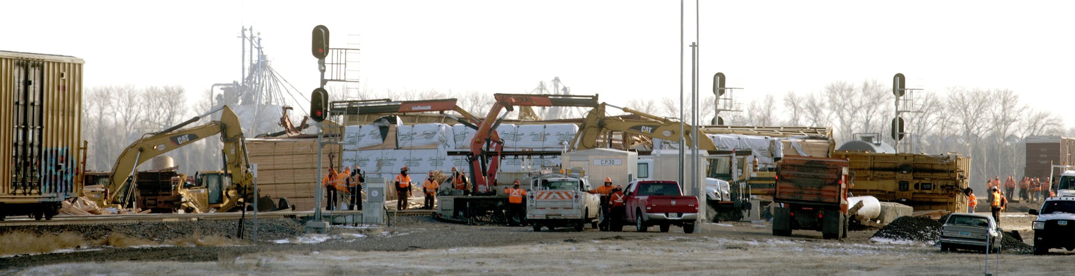 Crews clean up on Friday, Nov. 14, 2014, after two BNSF trains derailed just west of Casselton, N.D., on Thursday. BNSF Railway officials said it appears that a broken rail caused a derailment which affected 21 cars of an eastbound train carrying lumber and paper and 12 cars of a westbound train carrying empty oil tankers. There was no fire or hazardous waste spilled and no one was hurt. (AP Photo/Bruce Crummy)
