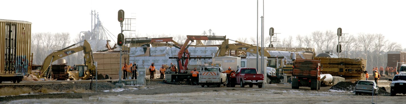 Crews clean up on Friday, Nov. 14, 2014, after two BNSF trains derailed just west of Casselton, N.D., on Thursday. BNSF Railway officials said it appears that a broken rail caused a derailment which affected 21 cars of an eastbound train carrying lumber and paper and 12 cars of a westbound train carrying empty oil tankers. There was no fire or hazardous waste spilled and no one was hurt. (AP Photo/Bruce Crummy)