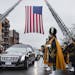 The funeral procession for New York Police Department Officer Wenjian Liu passes under an American flag in New York, Jan. 4, 2015. On Sunday, police o