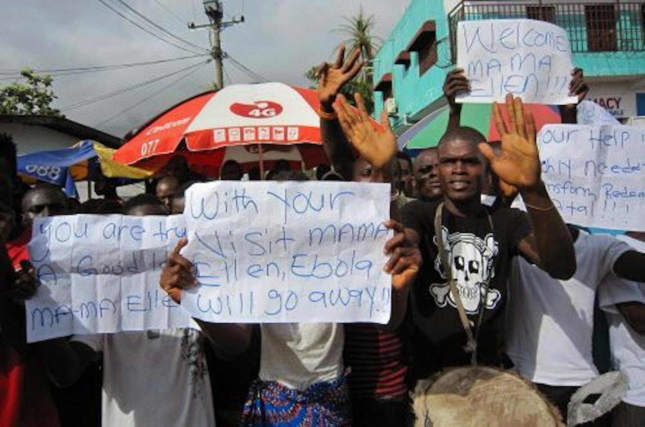 Outside a hospital in Liberia, people gather to greet President Ellen Johnson Sirleaf, who visited the area after Ebola death's in Monrovia, Liberia.