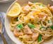 A bowl of salmon pasta has bright flavors with zucchini noodles, snap peas and lemon cream sauce.