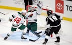 Minnesota Wild goaltender Cam Talbot, center, catches the puck on a shot by Los Angeles Kings right wing Alex Iafallo, right, with Wild defenseman Jar