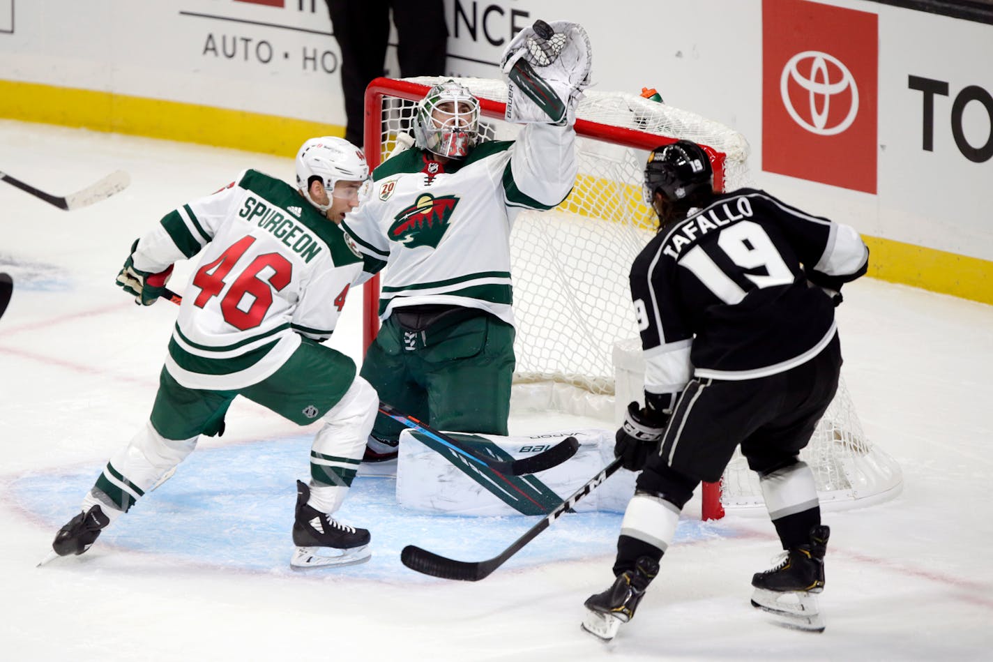 Minnesota Wild goaltender Cam Talbot, center, catches the puck on a shot by Los Angeles Kings right wing Alex Iafallo, right, with Wild defenseman Jared Spurgeon, left, defending during the second period of an NHL hockey game in Los Angeles, Thursday, Jan. 14, 2021. (AP Photo/Alex Gallardo)