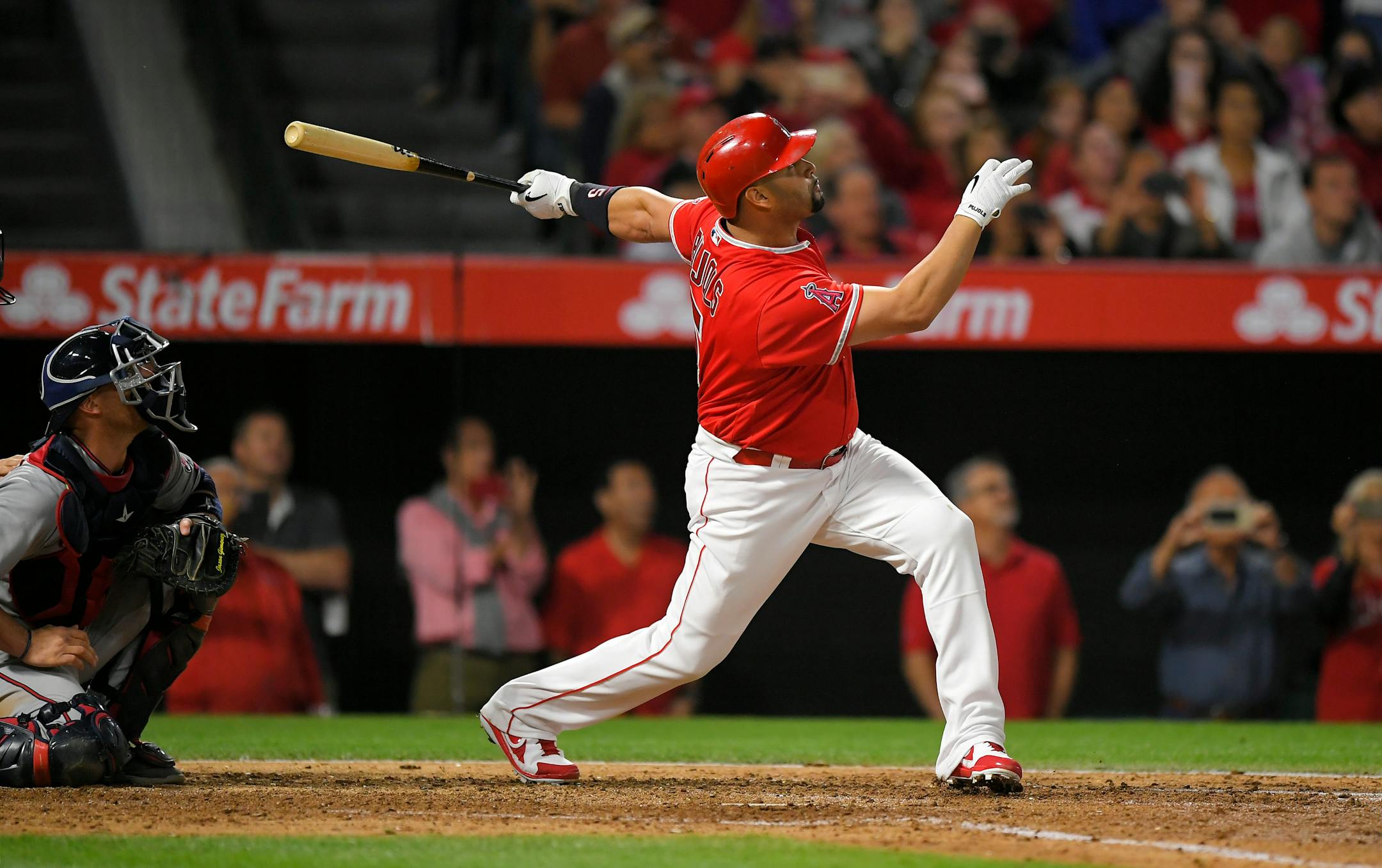 Los Angeles Angels' Albert Pujols, right, follows through on a grand slam, the 600th homer of his career, as Minnesota Twins catcher Chris Gimenez watches during the fourth inning of a baseball game, Saturday, June 3, 2017, in Anaheim, Calif.