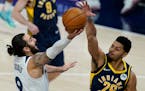 Minnesota Timberwolves' Ricky Rubio (9) has his shot blocked by Indiana Pacers' Jeremy Lamb (26) during the first half