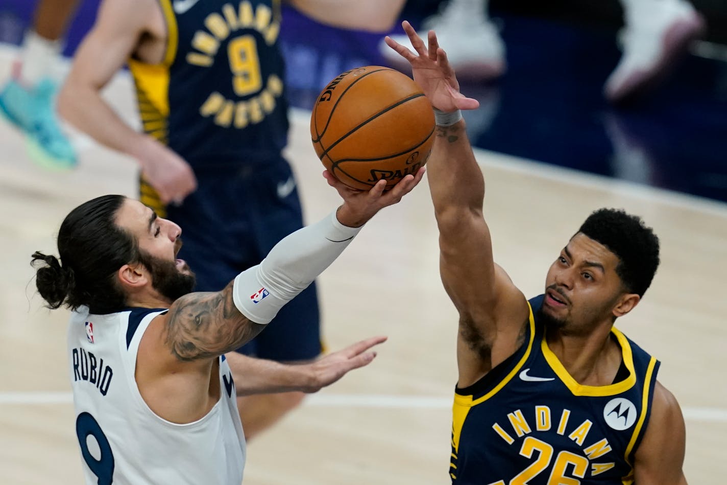 Minnesota Timberwolves' Ricky Rubio (9) has his shot blocked by Indiana Pacers' Jeremy Lamb (26) during the first half