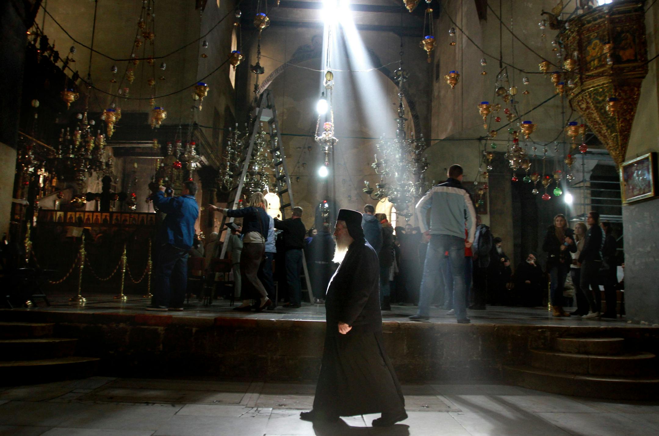 An Orthodox priest walks inside the Church of the Nativity, the site revered as the birthplace of Jesus, ahead of Christmas in the West Bank city of Bethlehem, Monday, Dec. 23, 2013. Christians around the world will celebrate Christmas this week. (AP Photo/Nasser Shiyoukhi)