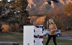 Emily Chatburn, who teaches 3rd grade at a local elementary school, puts her completed voter ballot into a drop box at a recreation center in Boulder,