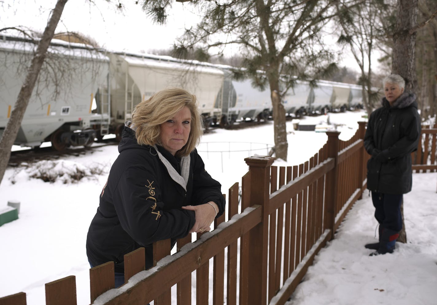 Pam Steinhagen, foreground, and her neighbor, Dee Volz in Steinhagen's back yard Wednesday afternoon. ] JEFF WHEELER &#xef; jeff.wheeler@startribune.com For seven years, Pam Steinhagen has had parked rail cars sitting on an unused stretch of track that runs behind her Lakeville house. She&#xed;s been an outspoken advocate for getting them moved, and has raised concerns about neighbors having to &#xec;police&#xee; the cars for trespassers and graffiti. Steinhagen and her neighbor, Dee Volz, were