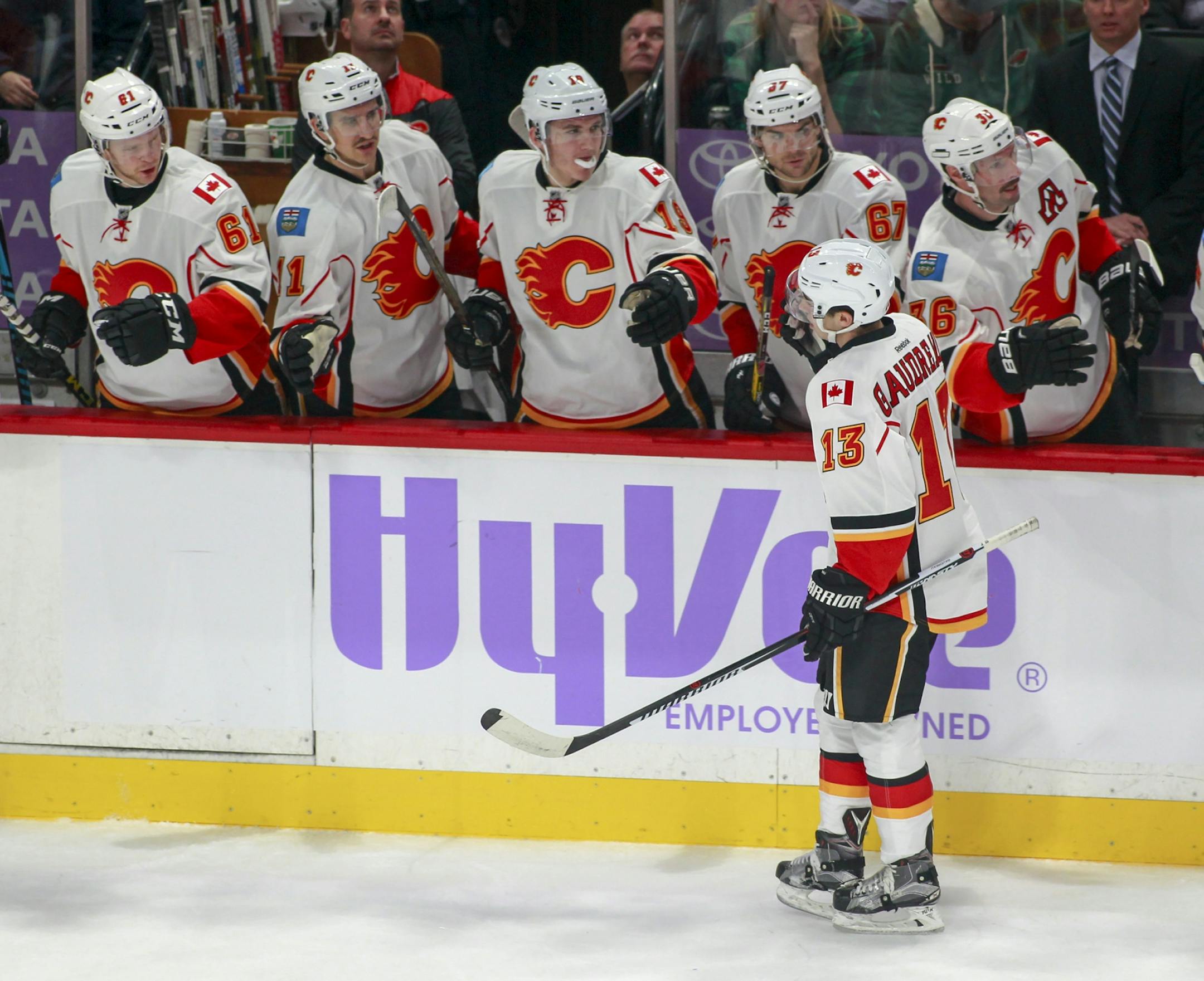 Calgary Flames left wing Johnny Gaudreau (13) is congratulated by teammates after he scored on a power play against the Minnesota Wild during the first period of an NHL hockey game, Tuesday, Nov. 15, 2016, in St. Paul, Minn.