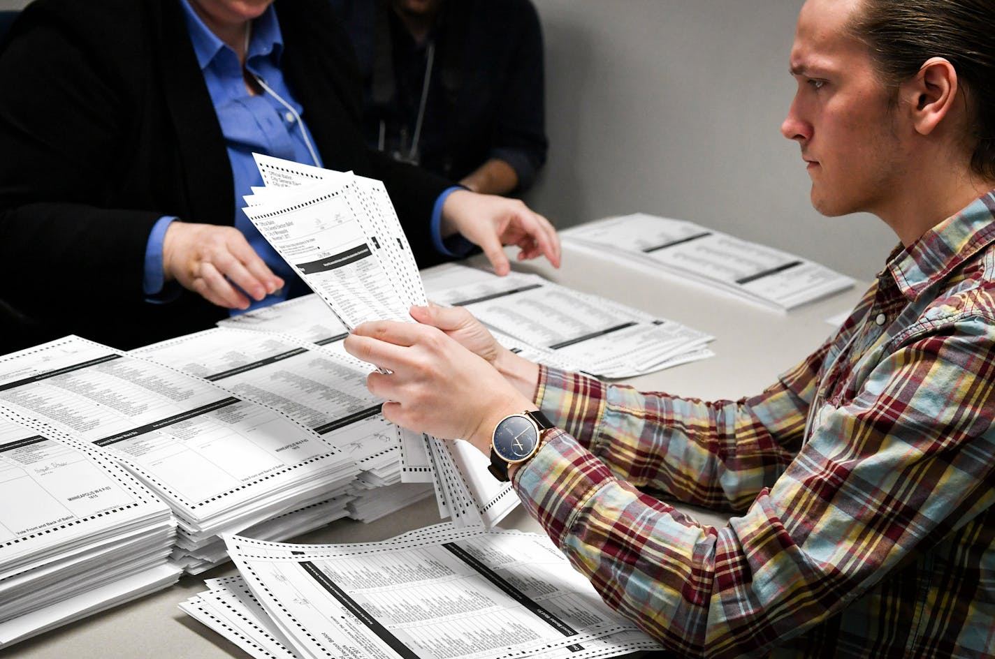 Election officials Alix Bentrud, left, and Andrew Hjermstad, right, sort ballots at the start of the Sixth Ward recount.