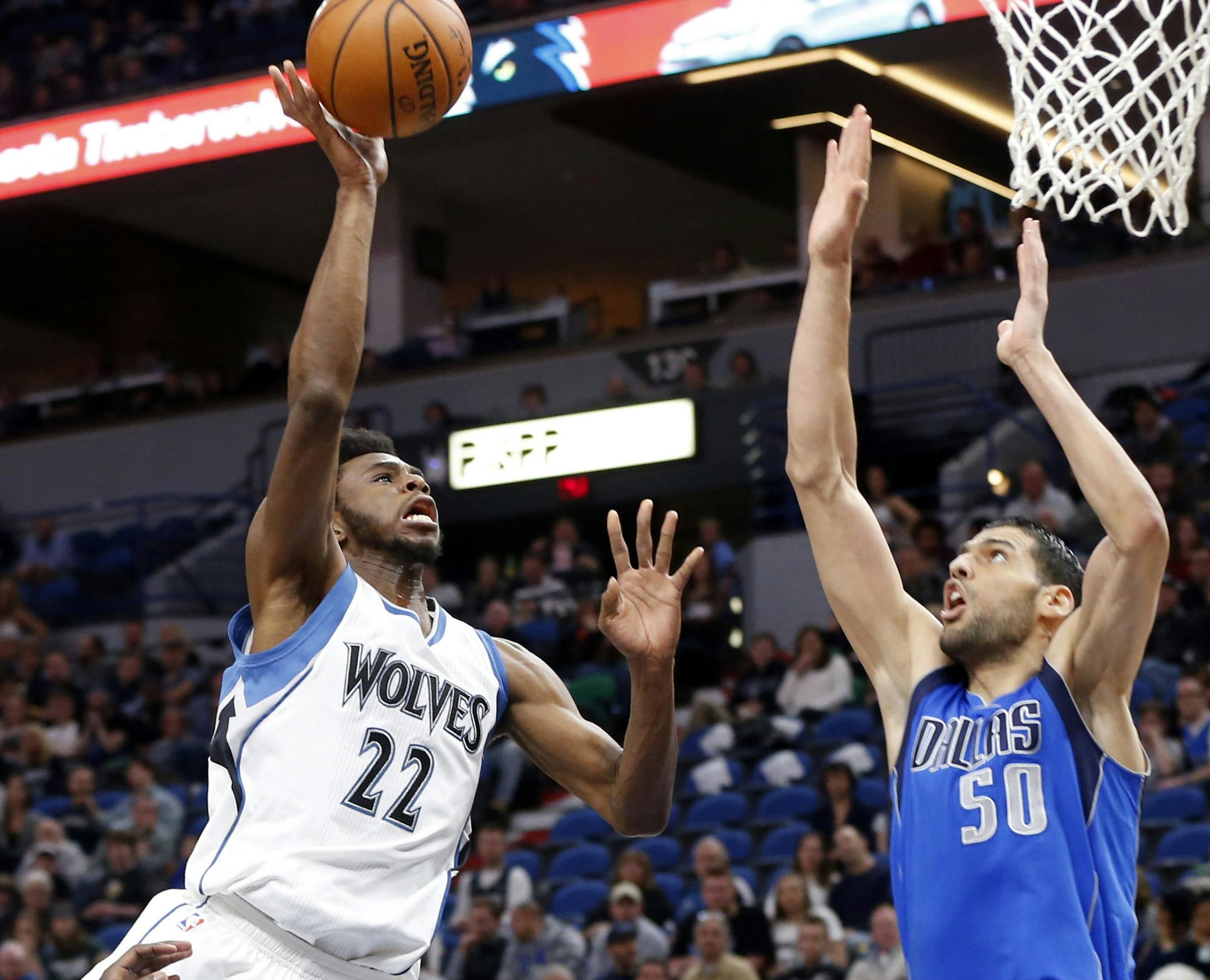 Minnesota Timberwolves' Andrew Wiggins, left, lays up as Dallas Mavericks' Salah Mejri, of Tunisia, defends during the first half of an NBA basketball game Friday, Feb. 24, 2017, in Minneapolis. (AP Photo/Jim Mone)