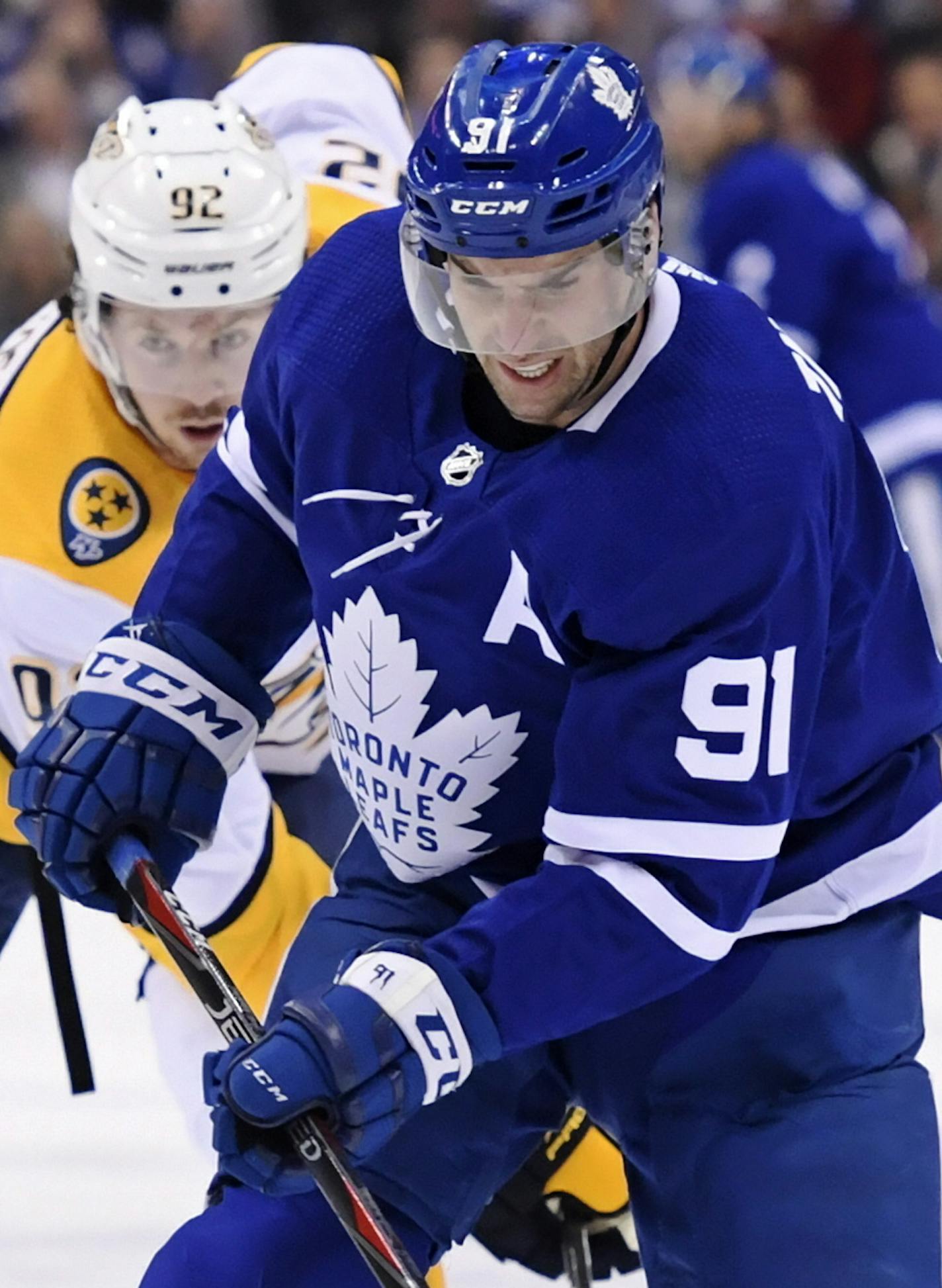 Toronto Maple Leafs center John Tavares (91) skates with the puck as he is chased by Nashville Predators center Ryan Johansen (92) during first-period NHL hockey game action in Toronto, Monday, Jan. 7, 2019. (Nathan Denette/The Canadian Press via AP)