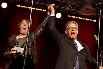 Sen. Amy Klobuchar (D-MN) and Sen. Al Franken (D-MN) celebrate onstage during Minneapolis Mayor Betsy Hodges' inauguration party at the historic Thorp