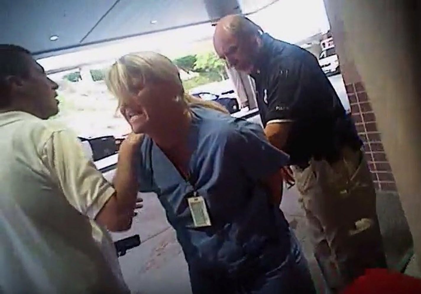 FILE - In this July 26, 2017, frame grab from video taken from a police body camera and provided by attorney Karra Porter, nurse Alex Wubbels is arrested by a Salt Lake City police officer at University Hospital in Salt Lake City. Wubbels, who was arrested for refusing to let a police officer draw blood from an unconscious patient said Tuesday, Oct. 31, 2017, that she was settling with Salt Lake City and the university that runs the hospital for $500,000.