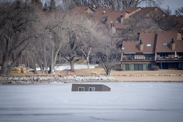 An ice house partially submerged and frozen into Lower Prior Lake in this winter of our discontent.