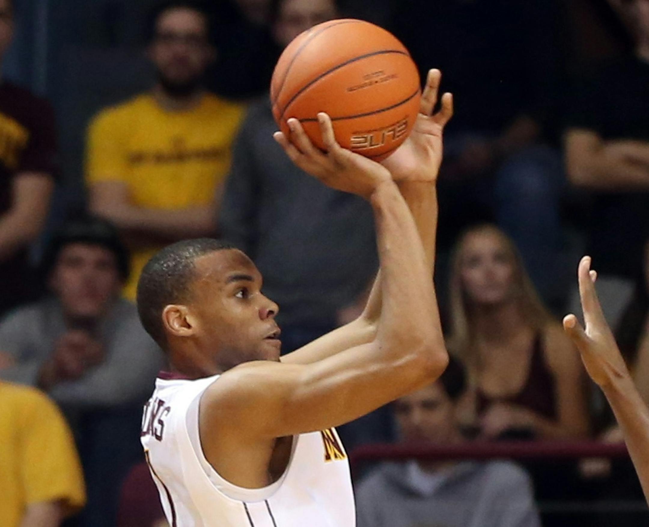 Minnesota&#x2019;s Andre Hollins, left, shoots as Rutgers&#x2019;s Junior Etou, of Congo, defends during the first half of an NCAA college basketball game, Saturday, Jan. 17, 2015, in Minneapolis. (AP Photo/Jim Mone)