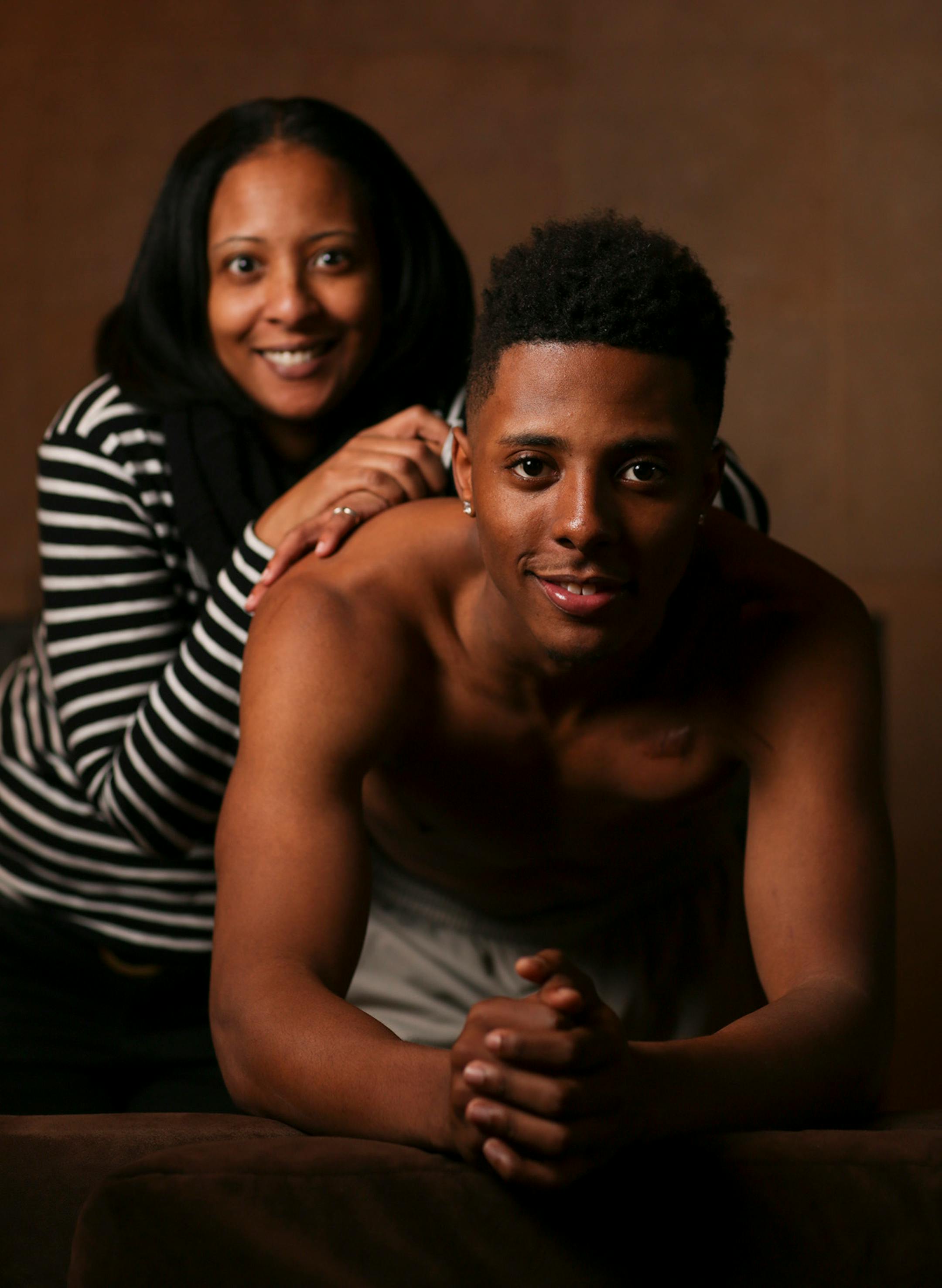 Jarvis Johnson with his mother, Tanisha, at his family's Brooklyn Park home. ] JEFF WHEELER • jeff.wheeler@startribune.com Jarvis Johnson, the DeLaSalle player who is the state's top basketball recruit, should be dead. His heart stopped for 12 minutes at the beginning of a practice when he was an eighth grader. Now with a defibrillator implanted in his chest, he's committed to the University of Minnesota. He was photographed at his family's Brooklyn Park home Thursday evening, January 15, 2015.