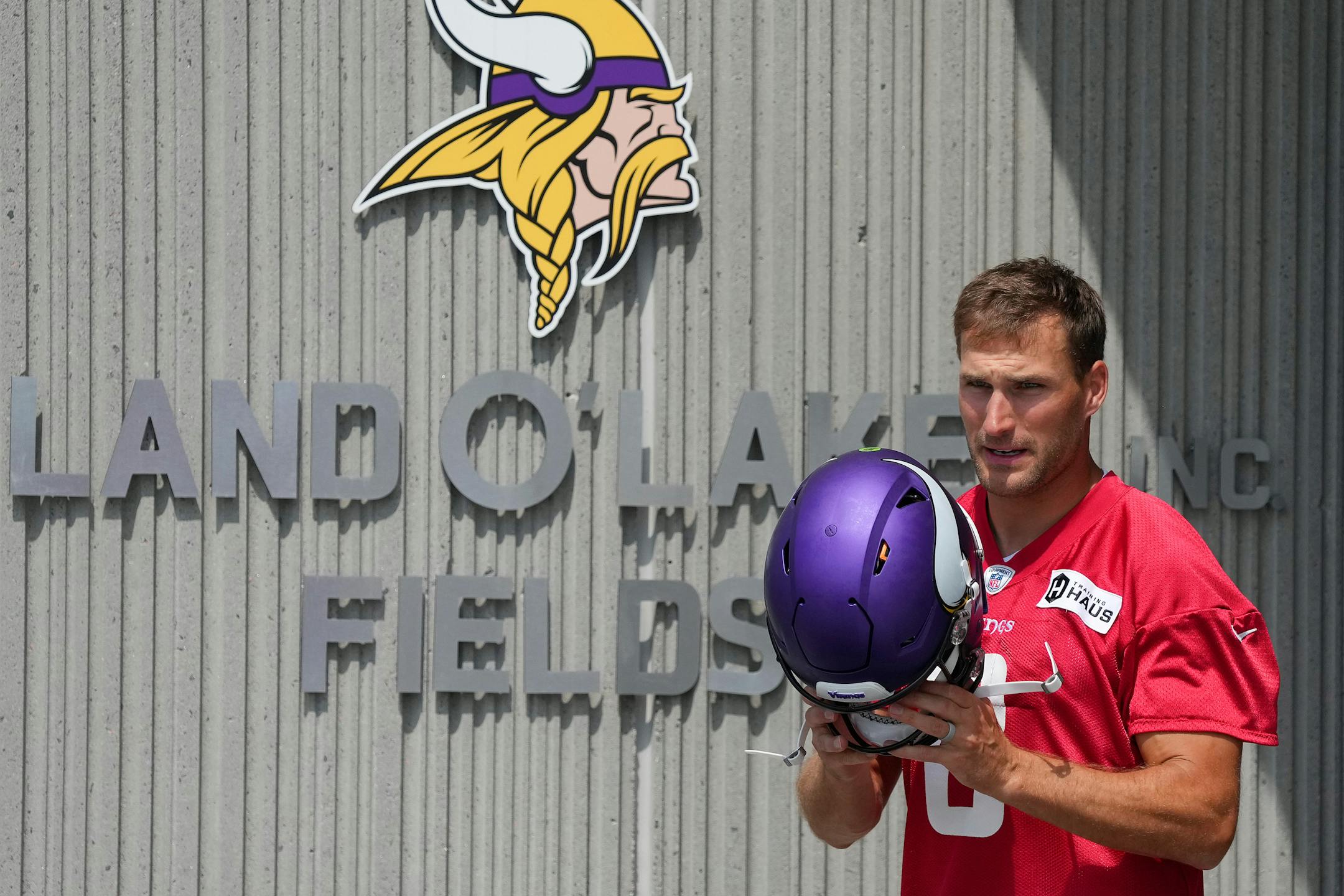 Minnesota Vikings quarterback Kirk Cousins (8) dons his helmet as he takes the field for training camp.