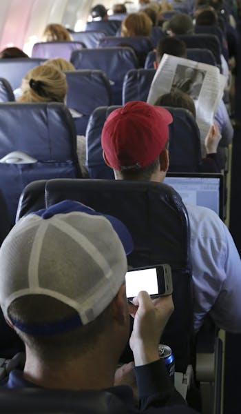 FILE -- Passengers use Wi-Fi services aboard a Southwest Airlines flight in Baltimore, April 26, 2013. The Federal Aviation Administration said Oct. 3