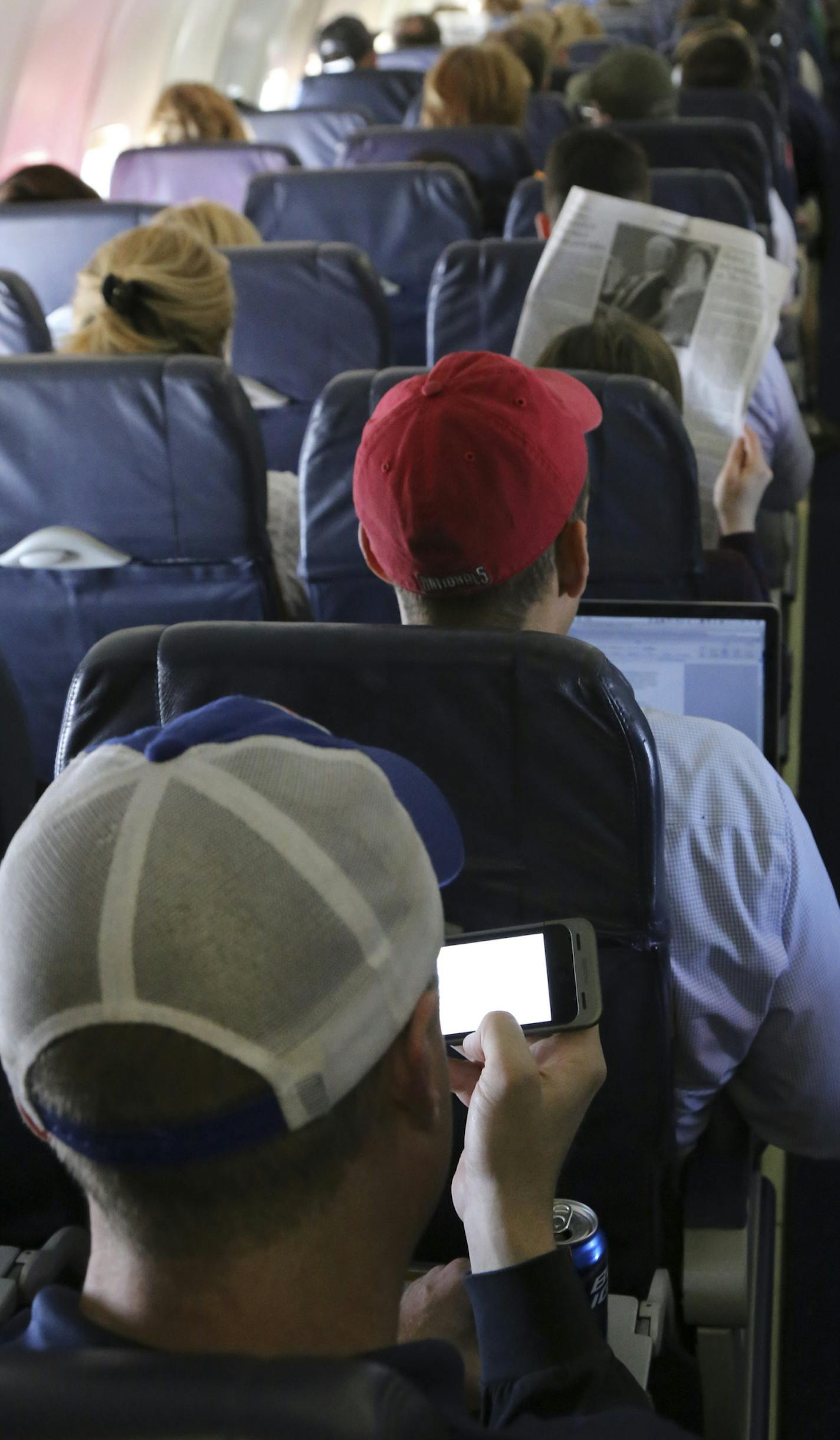 FILE -- Passengers use Wi-Fi services aboard a Southwest Airlines flight in Baltimore, April 26, 2013. The Federal Aviation Administration said Oct. 31, 2013 that airline passengers can use electronic devices in "all phases of flight" if the airline determines that its aircraft can tolerate the interference, but using a cellphone to talk will still be banned. (Marty Katz/The New York Times)