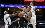 Nets guard Lonnie Walker IV, front right, controls the ball between Grizzlies guard Vince Williams Jr., left, and forward Ziaire Williams on Monday in