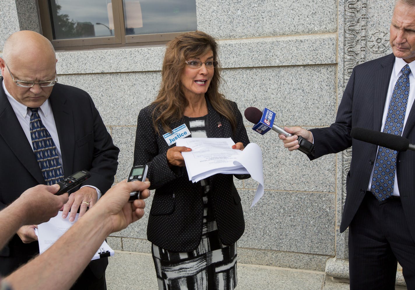 Michelle MacDonald, the Republican Party's endorsed candidate for Minnesota Supreme Court (center), announced a complaint filed against the party, Chairman Keith Downey and others, alleging they attempted to coerce her into giving up her endorsement.