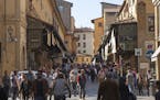 iStock Photo of Florence, Italy - April 22, 2015: view on Pont Vecchio from the old town (Via Por Santa Maria). The bridge and its shops attracts hund