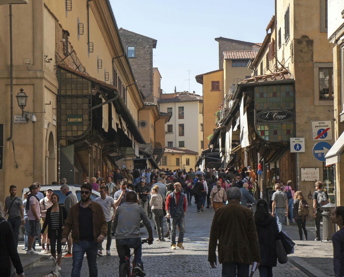 iStock Photo of Florence, Italy - April 22, 2015: view on Pont Vecchio from the old town (Via Por Santa Maria). The bridge and its shops attracts hundreds of visitors.