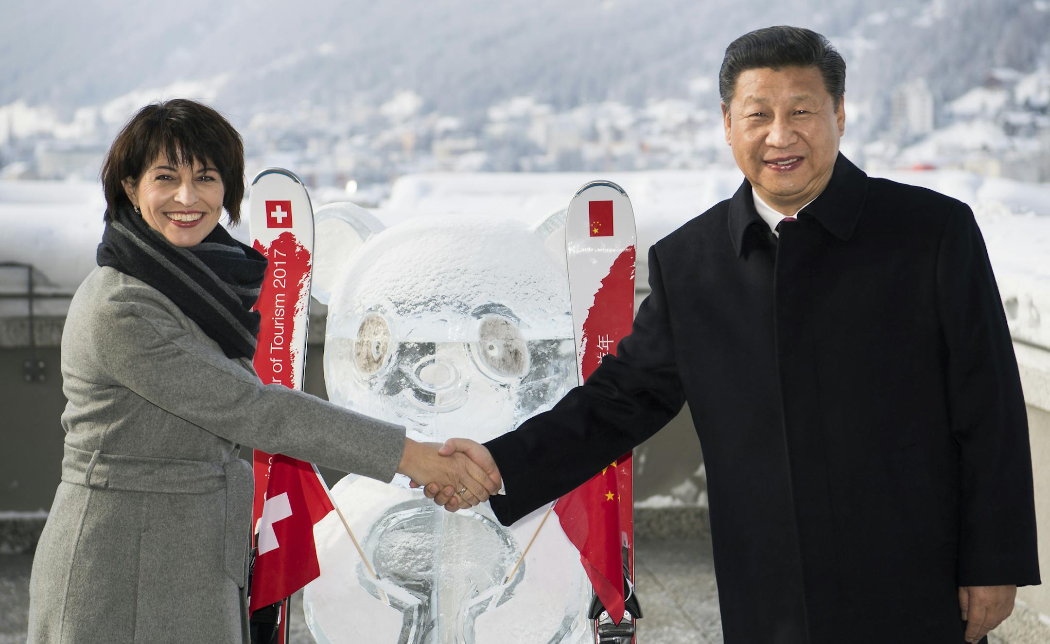 Swiss Federal President Doris Leuthard, left, shakes hands with China's President Xi Jinping, right, as they launch the Swiss-Sino year of tourism next to a panda ice sculpture on the side line of the 47th annual meeting of the World Economic Forum, WEF, in Davos, Switzerland, Tuesday, Jan. 17, 2017. (Laurent Gillieron/pool photo via AP)