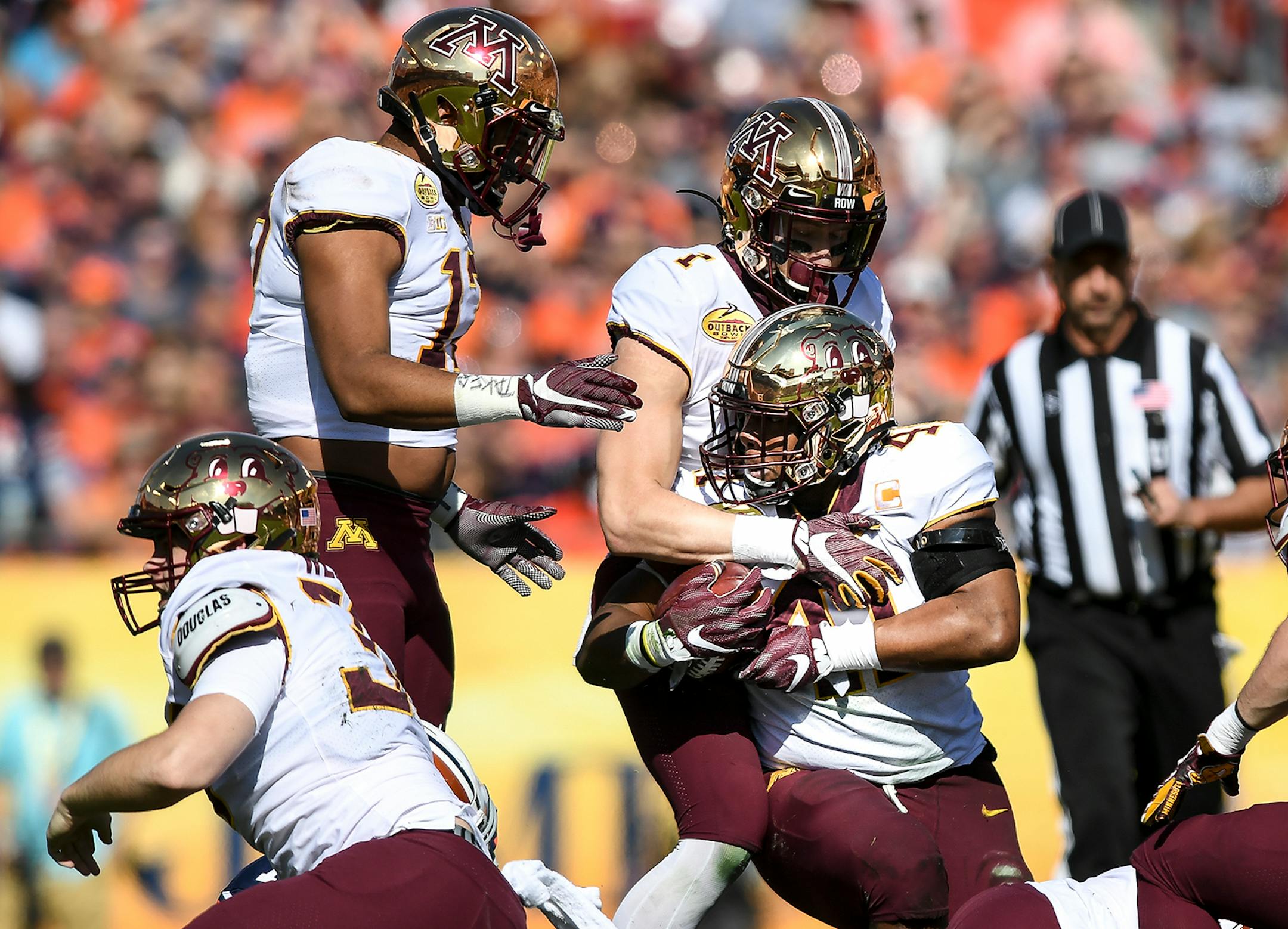 Teammates celebrated with Minnesota Gophers linebacker Thomas Barber (41) after he scooped up a fumble in the first quarter against the Auburn Tigers.
