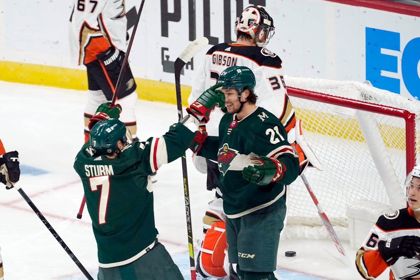 Minnesota Wild's Brandon Duhaime (21) is congratulated by Nico Sturm after Duhaime scored against Anaheim Ducks' goalie John Gibson during the first period of an NHL hockey game Saturday, Oct. 23, 2021, in St. Paul, Minn. (AP Photo/Jim Mone)