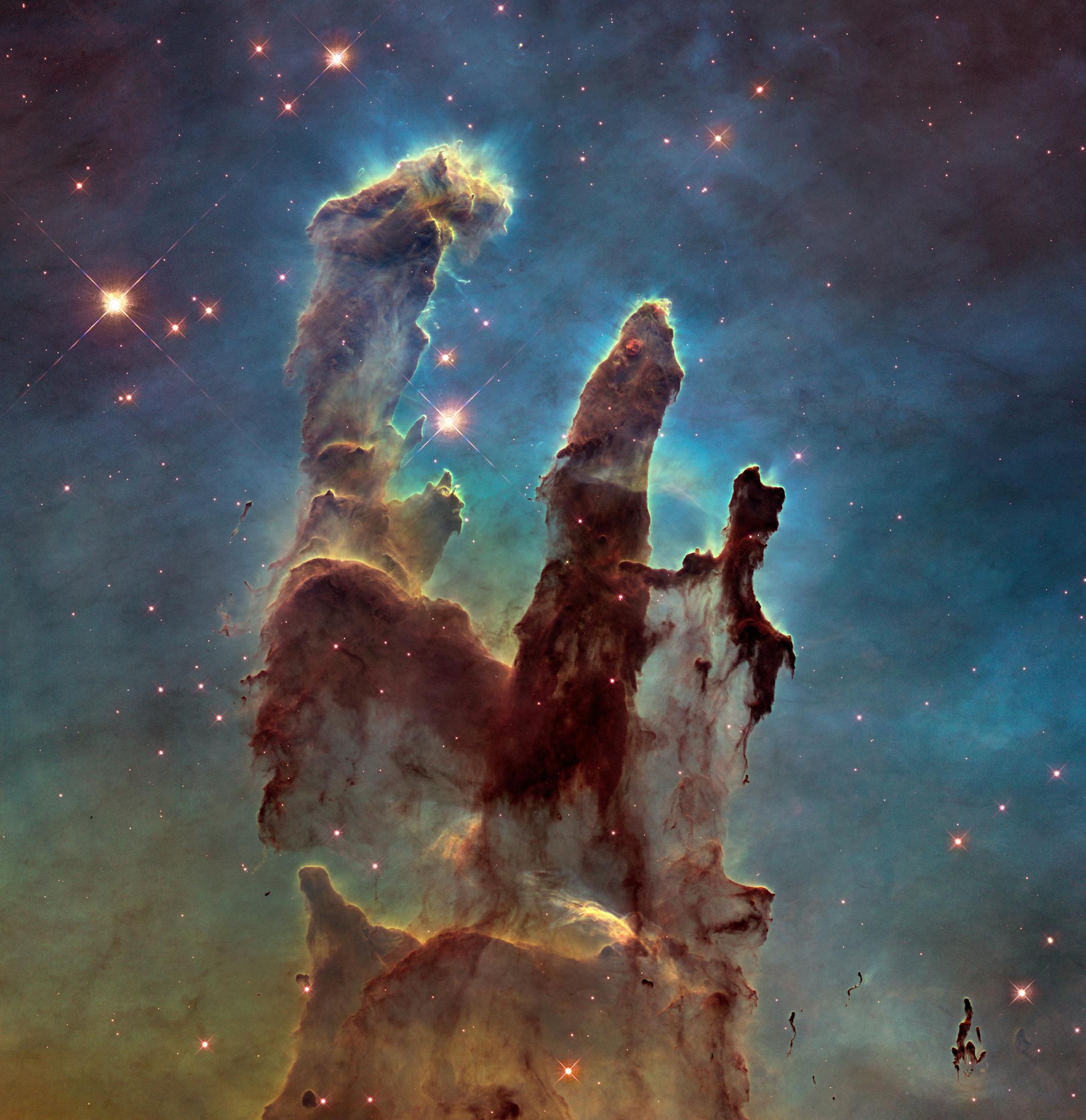 The NASA/ESA Hubble Space Telescope has revisited one of its most iconic and popular images: the Eagle Nebula‚Äôs Pillars of Creation. This image shows the pillars as seen in visible light, capturing the multi-coloured glow of gas clouds, wispy tendrils of dark cosmic dust, and the rust-coloured elephants‚Äô trunks of the nebula‚Äôs famous pillars. The dust and gas in the pillars is seared by the intense radiation from young stars and eroded by