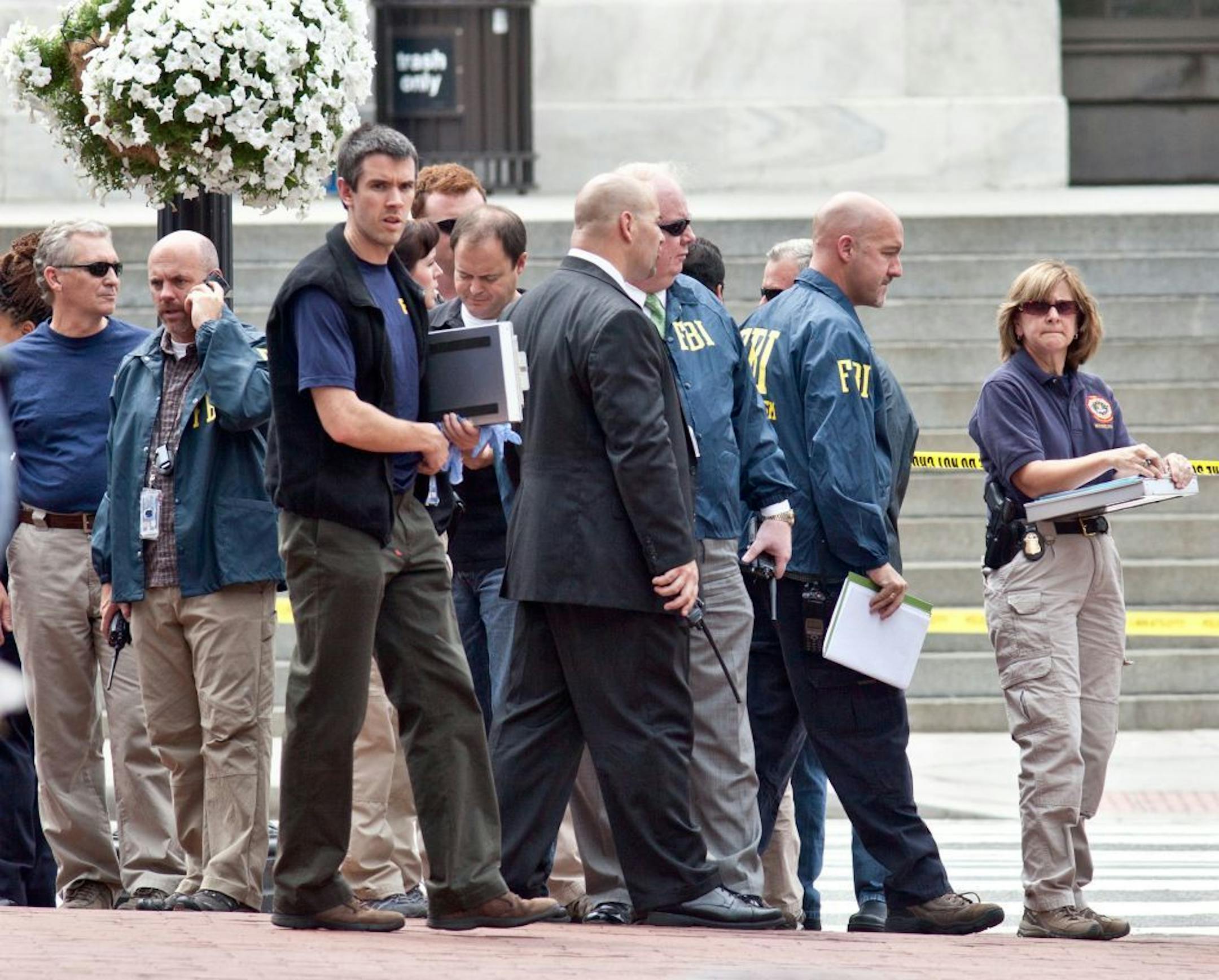Washington Police and FBI agents gather outside the Family Research Council in Washington, Wednesday, Aug. 15, 2012, after security guard at the lobbying group was been shot in the arm. A police spokeswoman says the shooting happened Wednesday morning at the Family Research Council. Police say one person has been taken into custody.