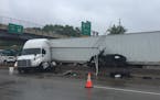 A car is pinned between a semi and the median after a collision on Interstate 94 westbound near Hudson, Wis., on Saturday, May 20, 2017. The driver of