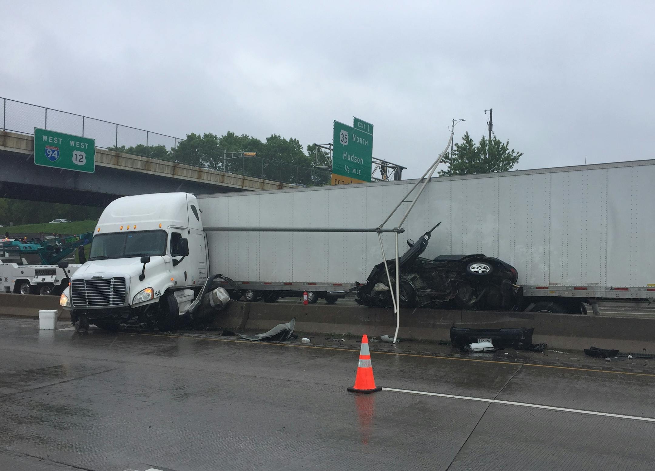 A car is pinned between a semi and the median after a collision on Interstate 94 westbound near Hudson, Wis., on Saturday, May 20, 2017. The driver of the car has life-threatening injuries.