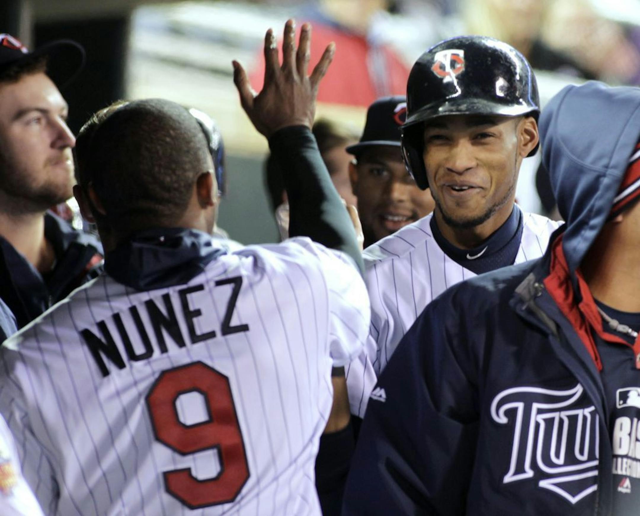 Minnesota Twins' Pedro Florimon is congratulated by teammate Eduardo Nunez after he scored the go-ahead run on a wild pitch by Toronto Blue Jays relief pitcher Sergio Santos during the eighth inning of the second game of a baseball doubleheader, Thursday, April 17, 2014, in Minneapolis. Minnesota won 9-5. AP Photo/Paul Battaglia)