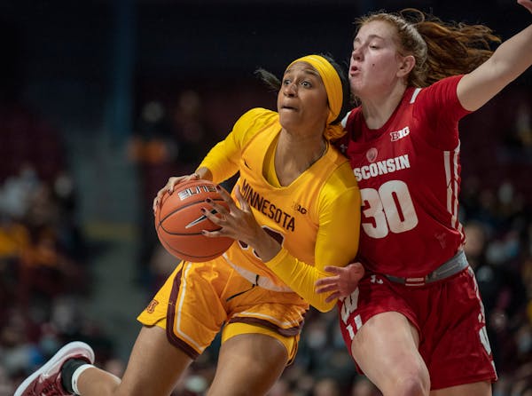 Minnesota Gophers forward Kadi Sissoko (30) drives to the basket on Wisconsin Badgers guard Sydney Hilliard (30) in the first half.