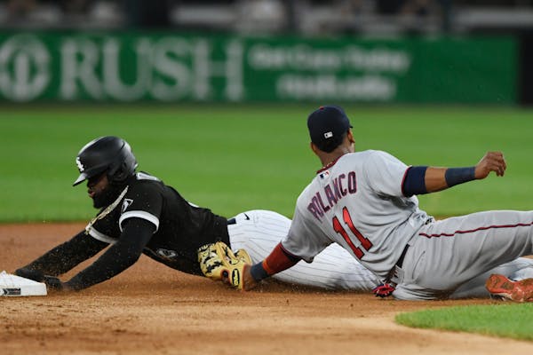 Twins second baseman Jorge Polanco, right, tags out Chicago’s Luis Robert on an attempted stolen base Tuesday.