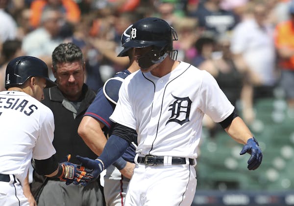 Detroit Tigers' JaCoby Jones, right, is greeted at home plate by Jose Iglesias (1) after hitting a two-run home run during the seventh inning of a bas